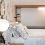 Quarto principal com cama aconchegante e cabeceira personalizada no projeto Leonardo Souza