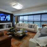 Sala de estar com decoração moderna e móveis de madeira no projeto de Aline Zagonel